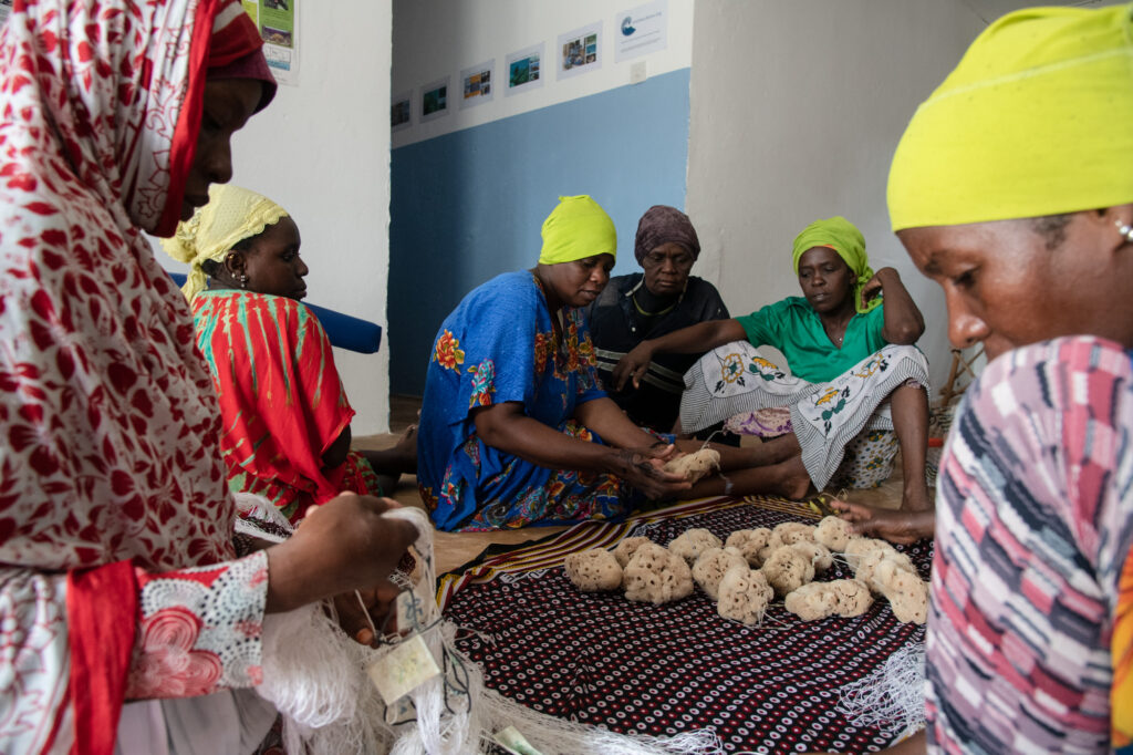 The women bring the cleaned and washed sponges back inside to inspect and set a price, between 20 and 25 USD. They processed all of the sponges together but can tell which are their individual sponges. They separate them and each sell their own.